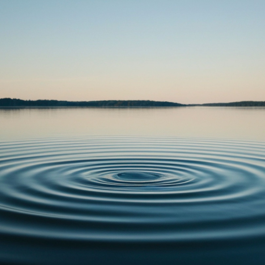 A calm pond surrounded by nature with gentle ripples spreading across the water, symbolizing reflection, renewal, and the lasting impact one person can have through knowledge and service.